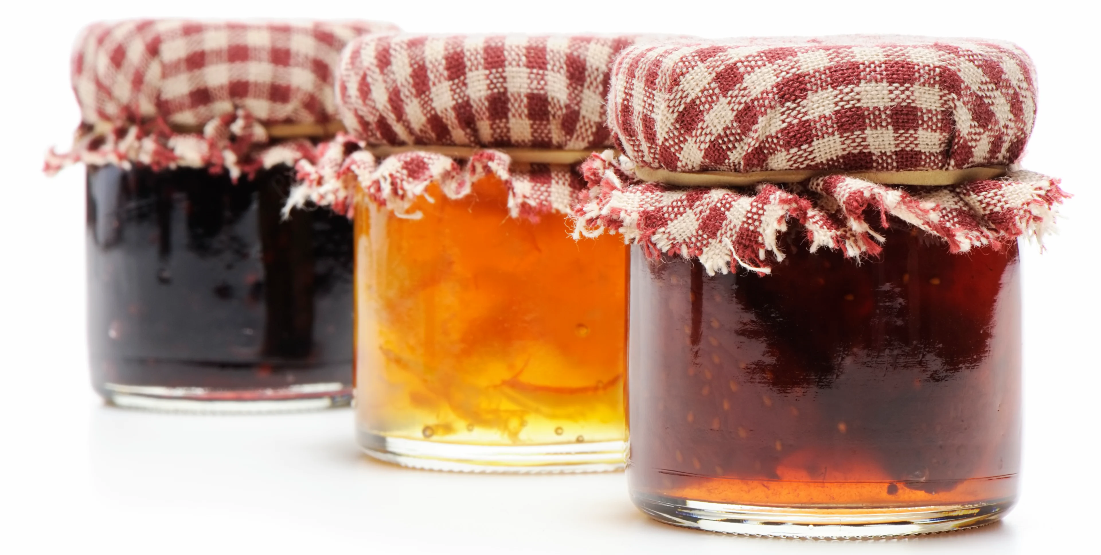 Three jars of jam with checkered lids.