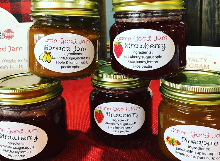 Jars of assorted fruit jams on display.