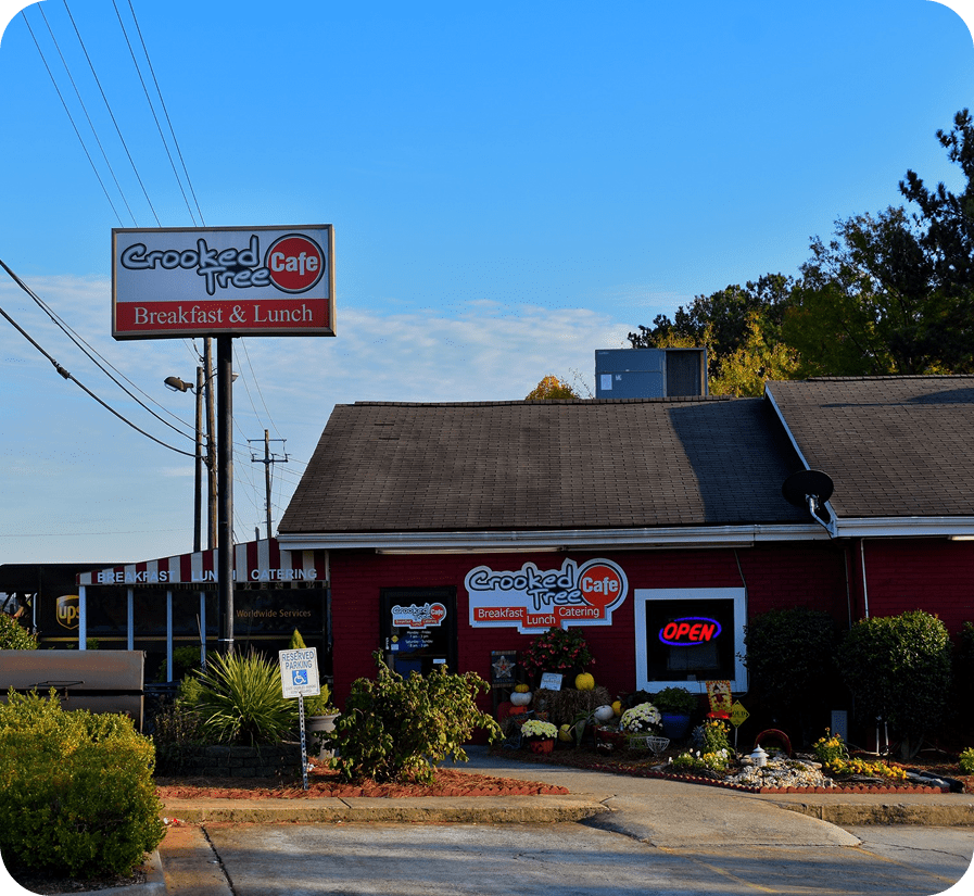Red cafe building with signage and flowers.