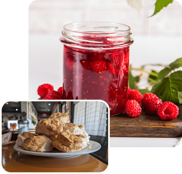 Fresh raspberry jam in a jar with toast on a plate.